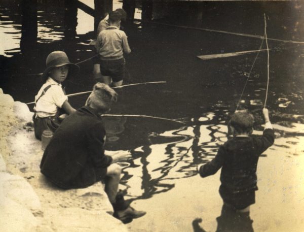Young boys fishing in the river for fish during the depression 1930