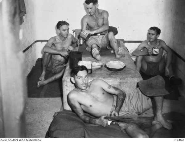 Ex-POWs show the conditions of their cell at Changi. The men appear malnourished and have minimal comforts