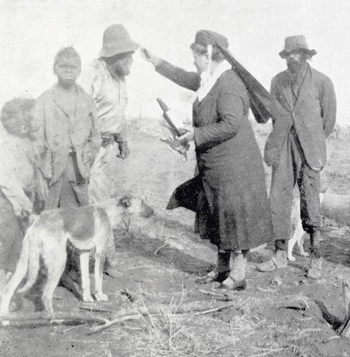 Photograph from “The “Good Fella Missus” by Violet Turner Adelaide 1930 of Annie Lock administering cough medicine. ‘The United Aborigines Mission (UAM) used such images to illustrate the practical work done by missionaries, contrasting the efficient, neatly uniformed, well-fed missionary with badly dressed, improved-looking Indigenous people in a desolate environment, underscoring the apparent need for the UAM.