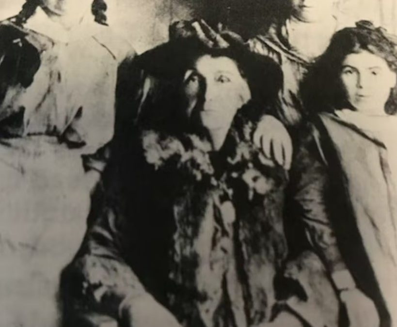 A black and white photograph of Mary Jane Cain in the centre, surrounded by her granddaughters Miley Barker and Milly Chatfield, and her great niece Josephine.