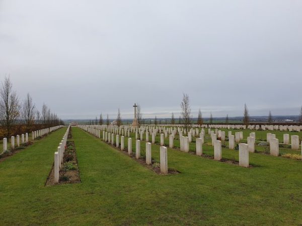 The Villers-Bretonneux military cemetery lined with hornbeam trees and the Cross of Sacrifice in the distance 2019.