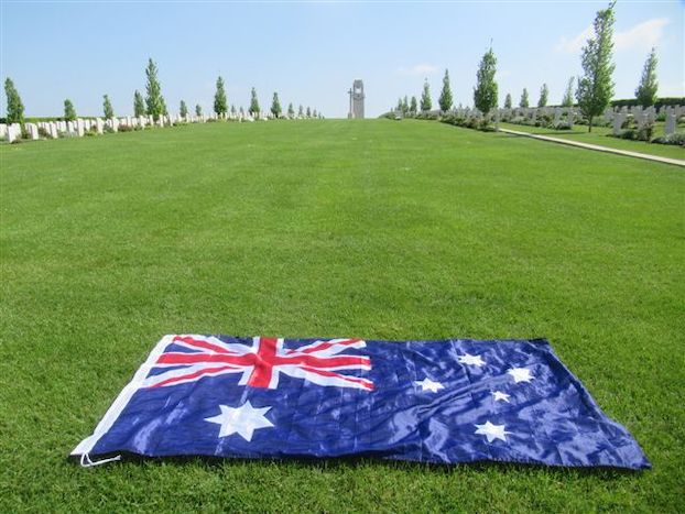 An Australian flag lays on the grass surrounding the memorial at Villers-Bretonneux 2020.