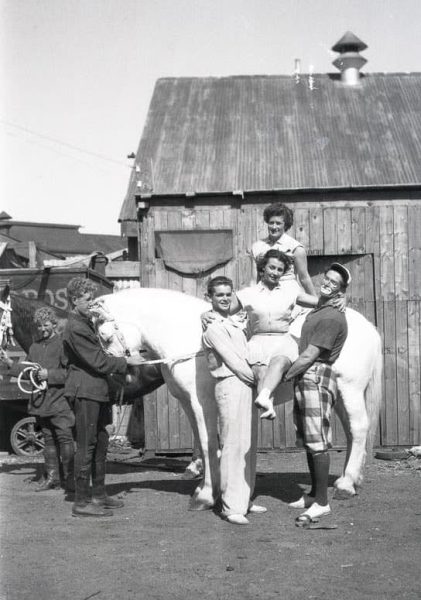 Black and white photo of the St Leon Family riding a horse. Peggy St Leon held by brothers Leo and Joe, sister Stella behind on the horse.