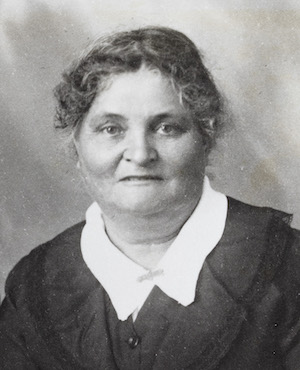Black and white photograph of Anne Johansen, in 1937. She wears a black jacket and a white blouse