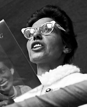 Photograph of Oodgeroo Noonuccal, then known as Kath Walker, reading from her own poerty collection at the National Aborigines Day celebration in Martin Place, Sydney, 9 July 1965.