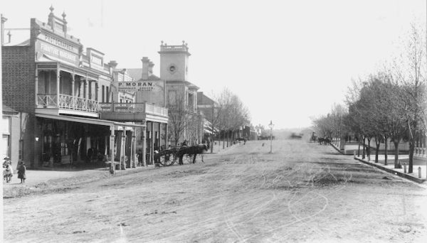 Black and white photograph of Fitzmaurice Street in Wagga Wagga featuring unpaved dirt roads. The clocktower is visible in the background.