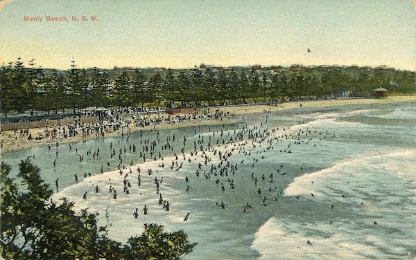 Postcard depicting Manly Beach, showing swimmers entering the surf.