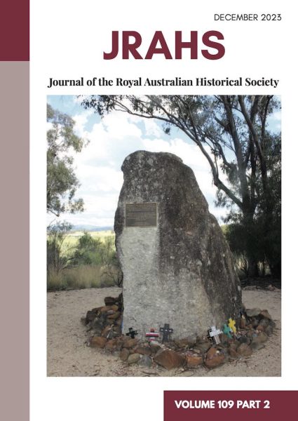 A photograph of Memorial Rock at the Myall Creek Massacre Site on the RAHS Journal's cover. A plaque is fixed onto the rock. Laid at the rock's base are small crucifixes.