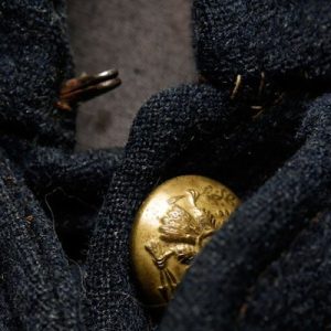 A close-up of a Civil War jacket showing its woollen fabric and golden buttons.