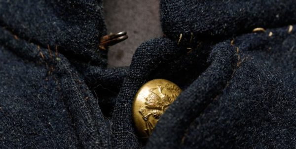 A close-up of a Civil War jacket showing its woollen fabric and golden buttons.