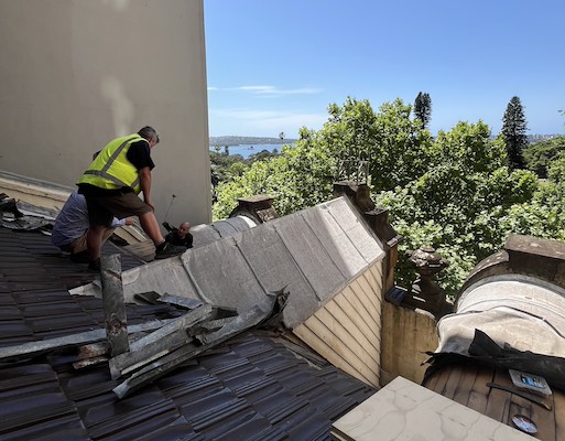 Roof works underway at History House, showing the removal of existing roof materials and preparation for the new copper covering. View looking east towards Sydney Harbour.