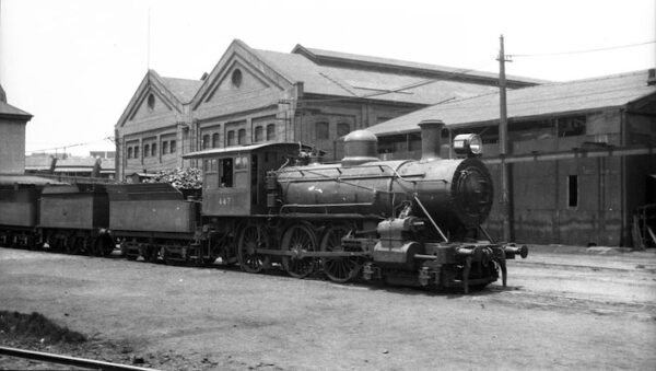 NSW Government Railway Class O-446 steam train on tracks outside Eveleigh Locomotive Workshops.