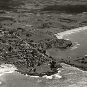 Aerial view of Kiama looking northwest. The foreground features Bombo Beach, Kiama ocean pool, Black Beach, Kiama harbour, Kiama Surf Beach, with a view of rural farmland in the background.