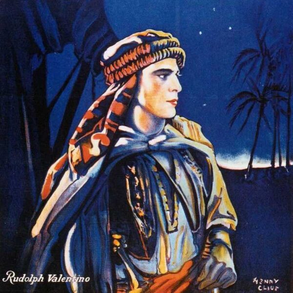 A film poster featuring actor Rudolph Valentino dressed as a sheik against the backdrop of a desert landscape.